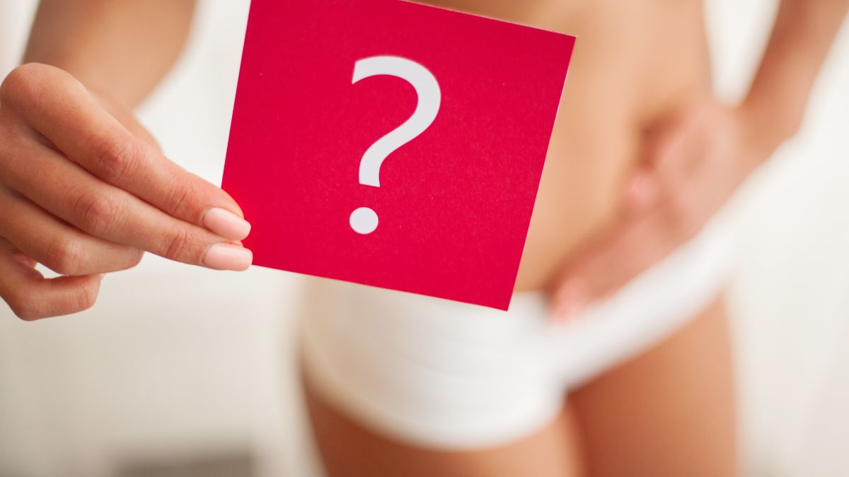 Egy nő kezében piros kérdőjel jelzés, a menstruációval kapcsolatos kérdésekre utalva.